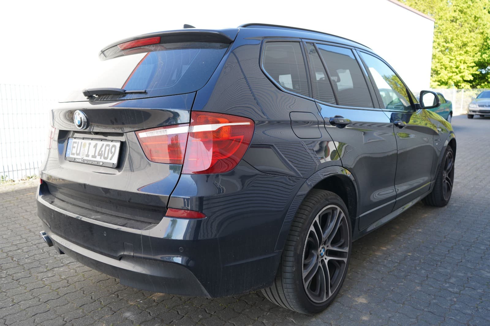 Heckansicht eines schwarzen BMW X3 zur Dokumentation eines Schadensfalls durch einen Gutachter.