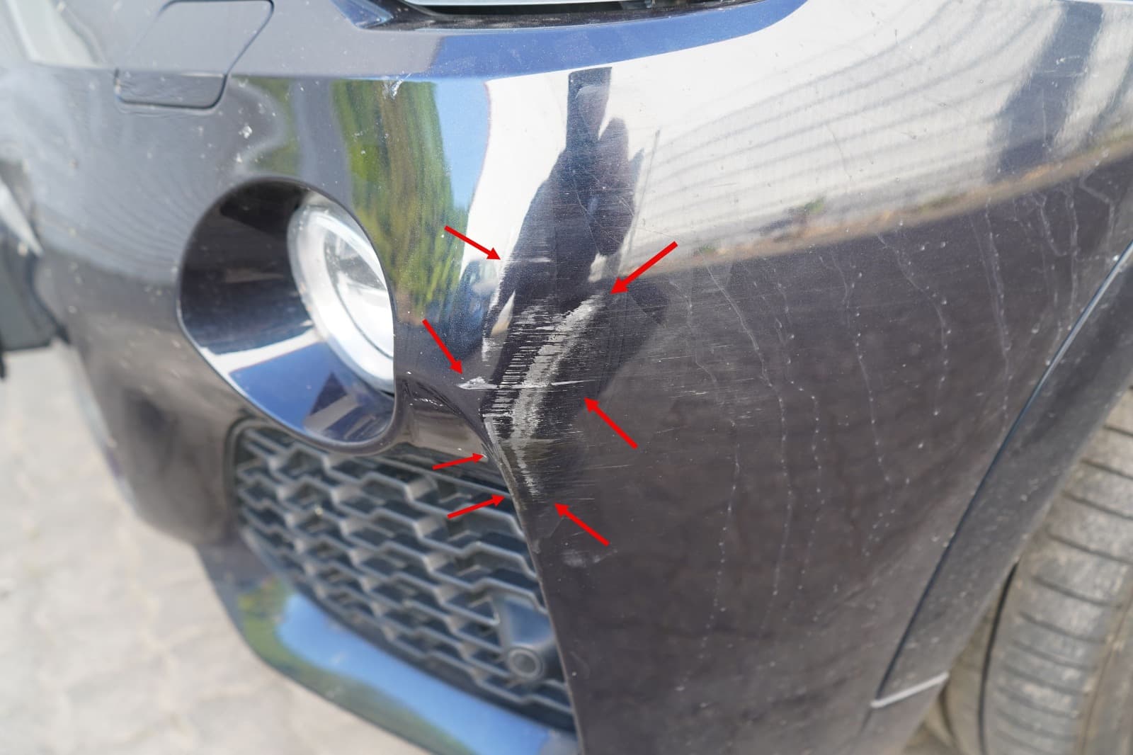 Nahaufnahme eines markierten Frontschadens am BMW X3 durch einen Kfz-Gutachter in NRW.