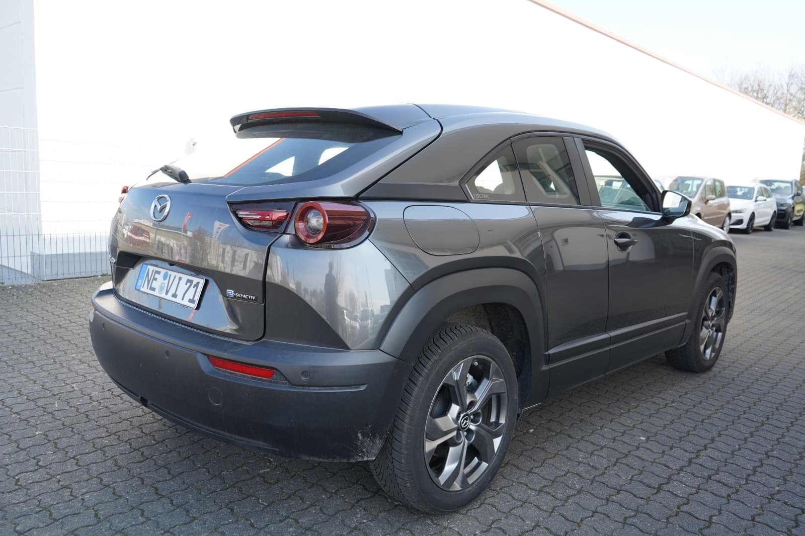Heck- und Seitenansicht eines grauen Mazda MX-30 als Abschlussbild der Schadenaufnahme.