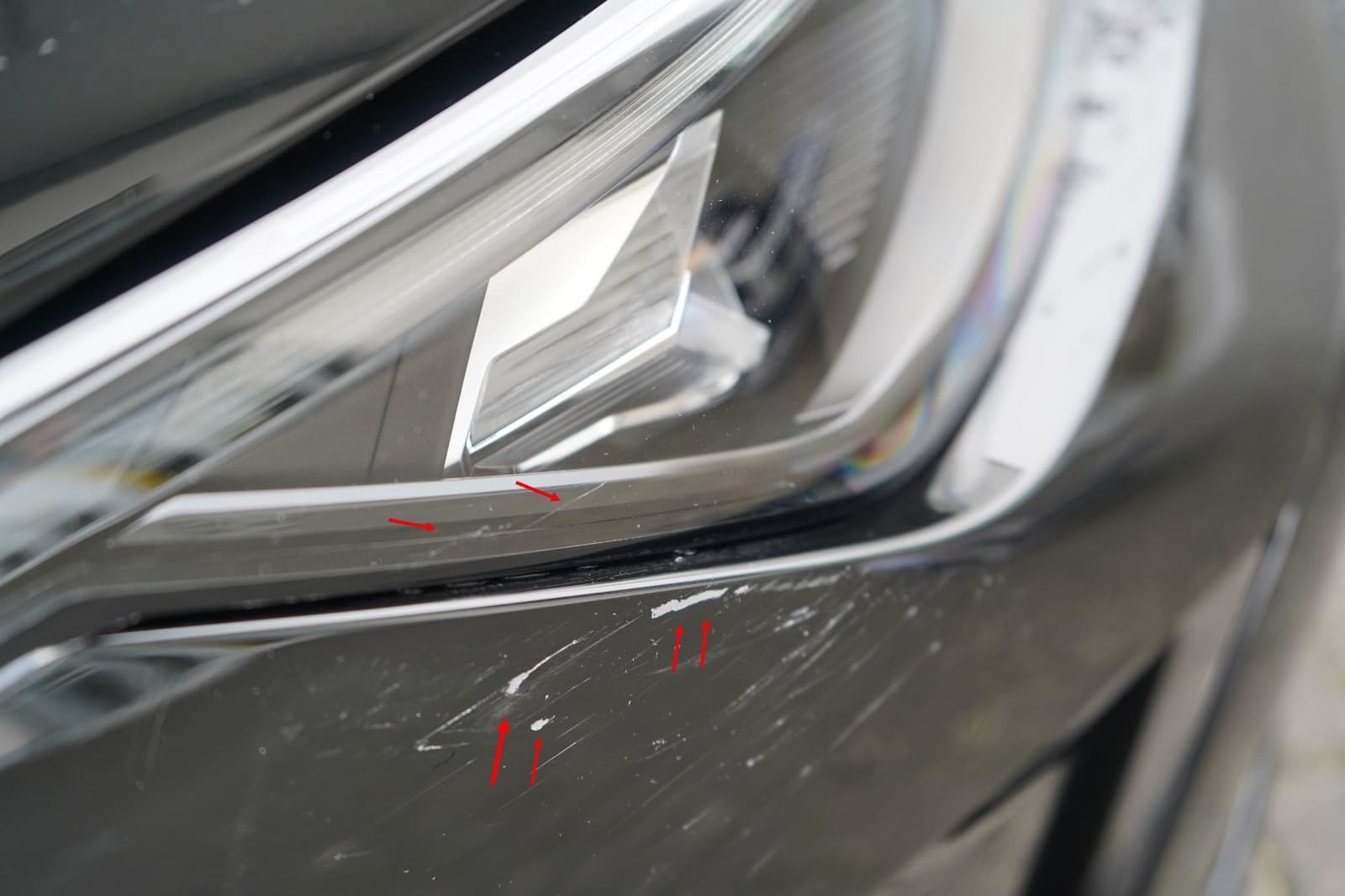 Nahaufnahme von Lackspuren am Frontbereich eines VW Golf fur die gutachterliche Dokumentation.