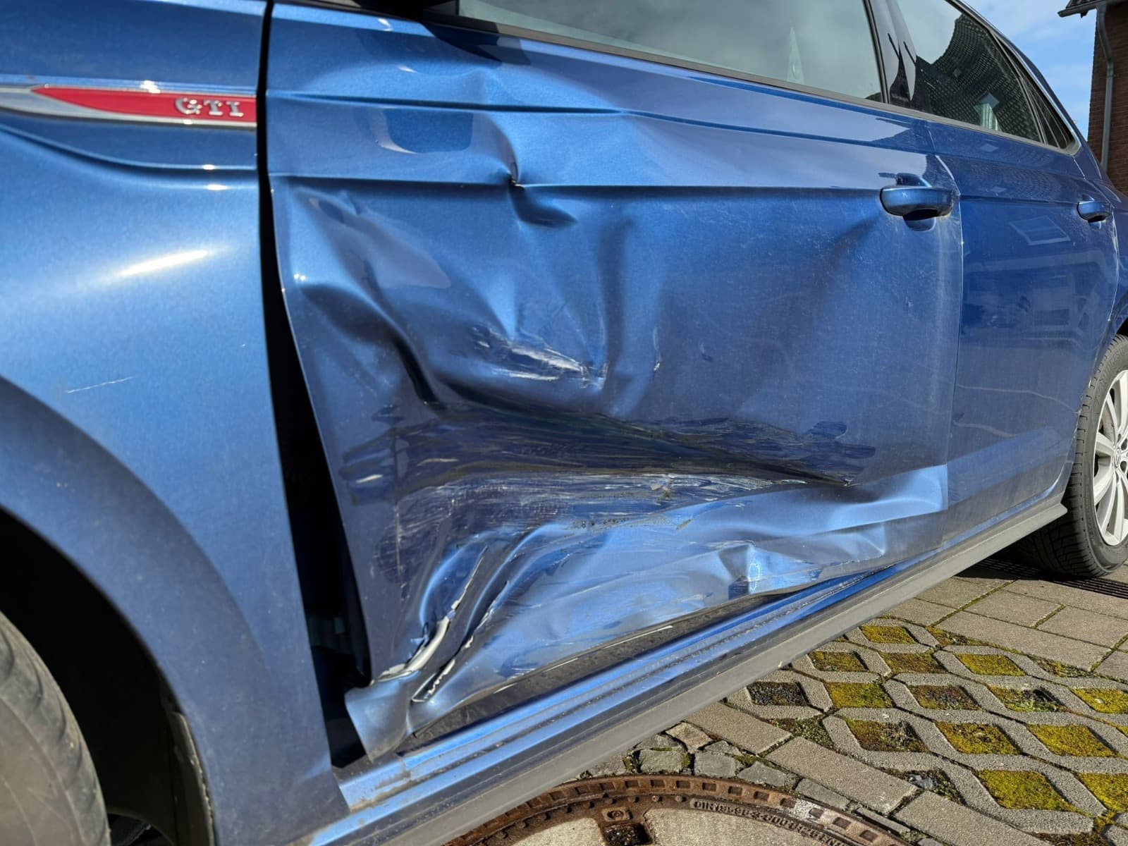 Detailaufnahme des Seitenschadens am blauen VW Polo fur ein Gutachten in Euskirchen.