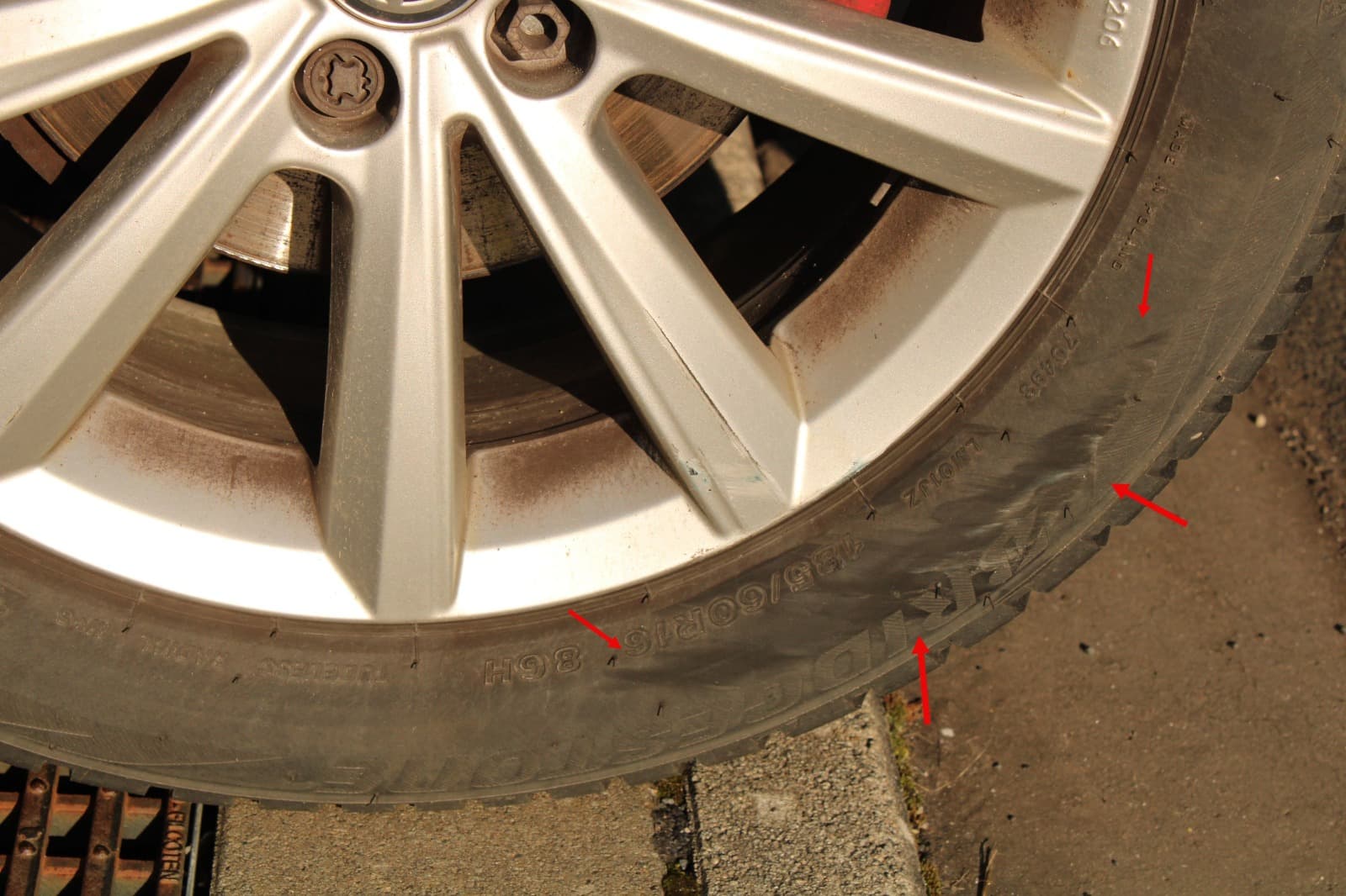 Nahaufnahme von Reifen- und Felgenbereich eines VW Polo mit markierten Schadenspuren.