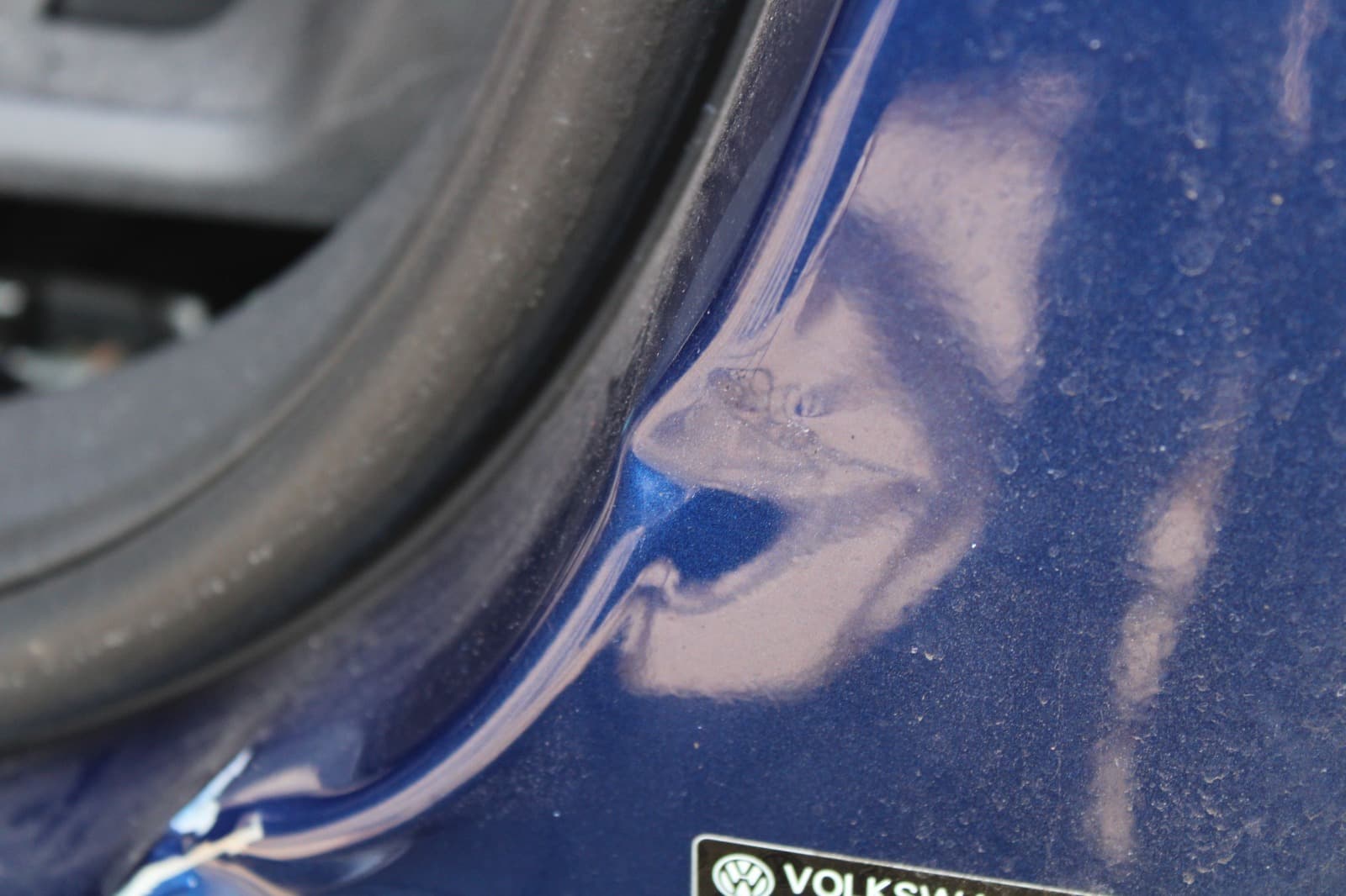 Detailaufnahme des Tureinstiegs eines blauen VW Polo als Referenz fur ein Gutachten.